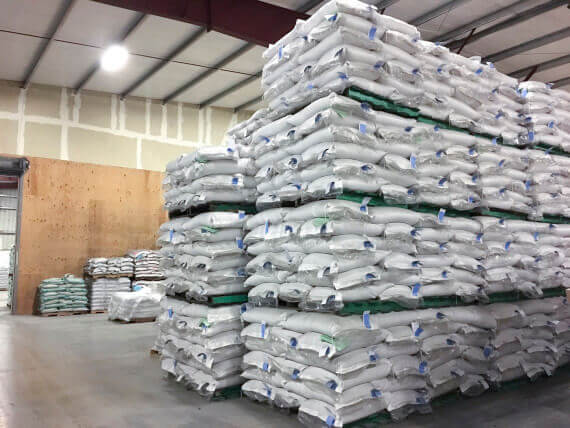 Poly Woven bags stacked and palletized in a warehouse.